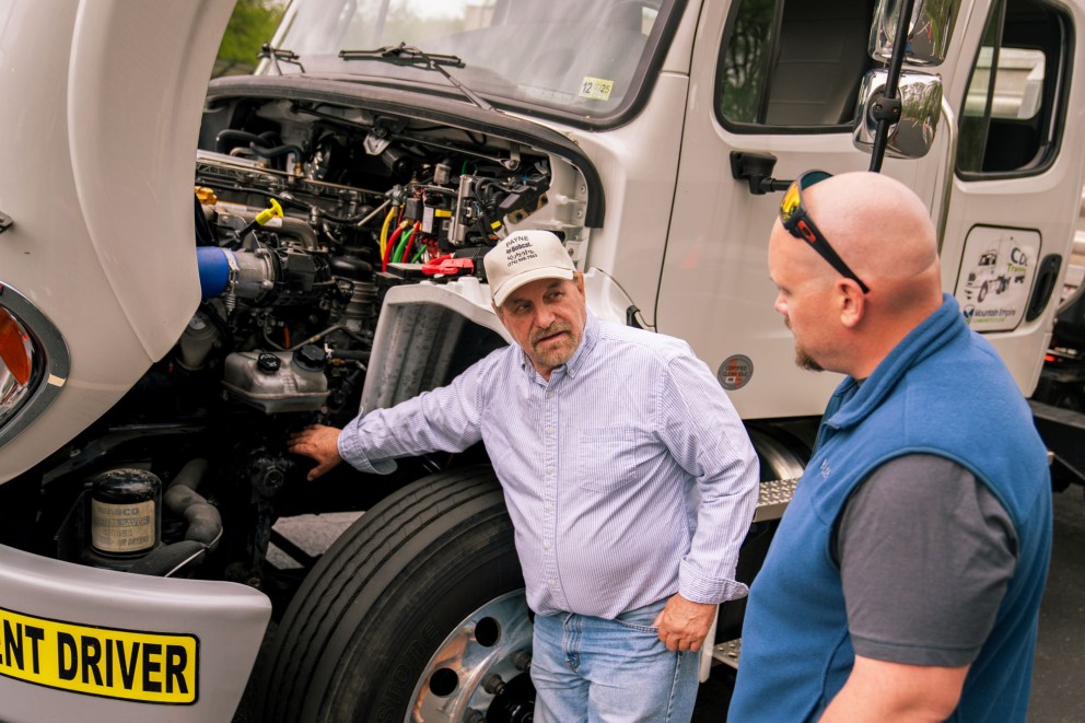 men inspecting truck engine